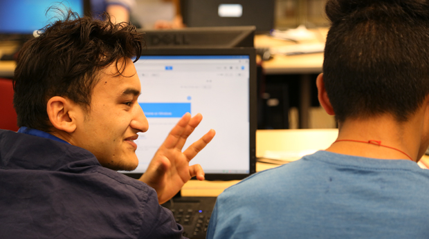 Two students discussing project in front of computer in the Wright Library